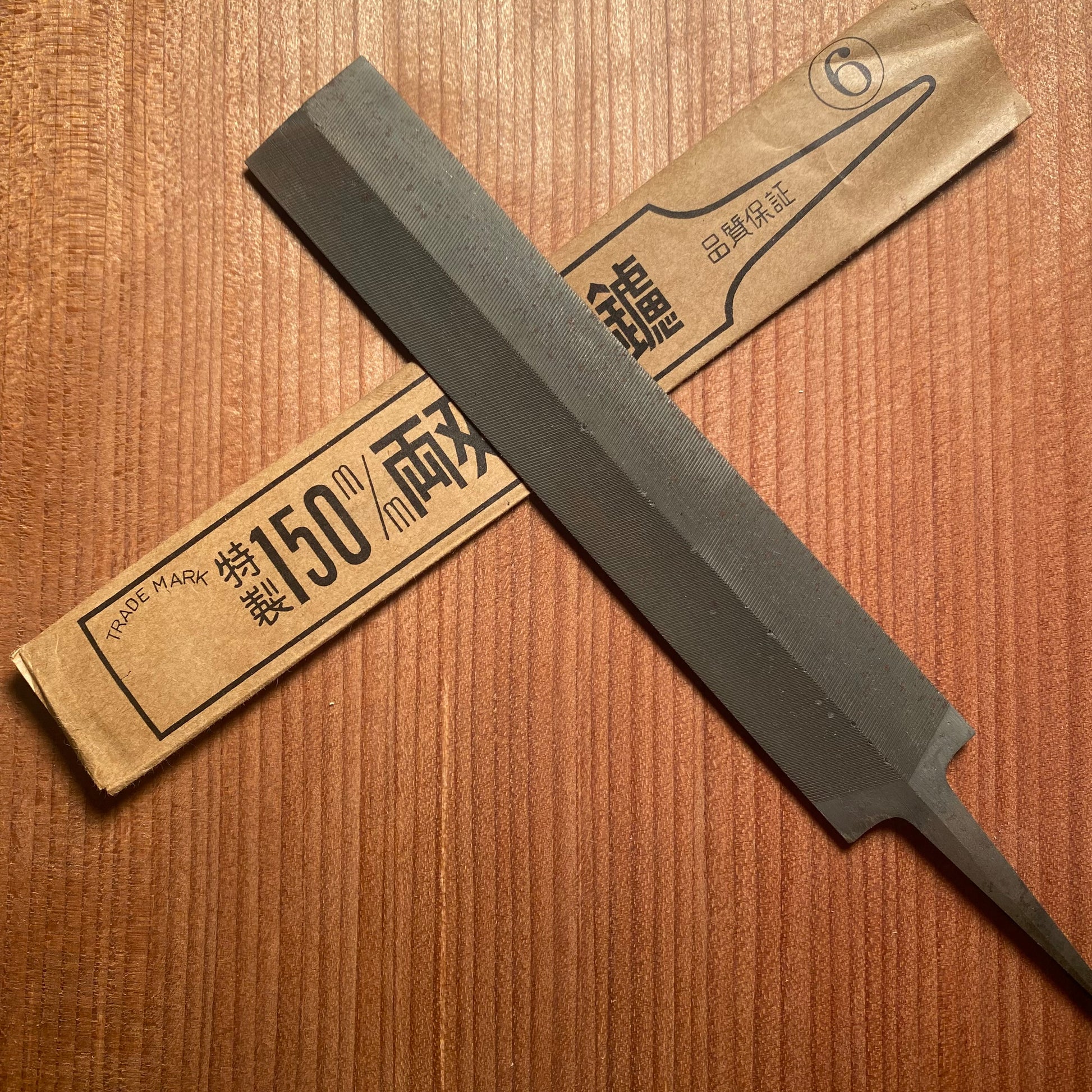 Feather file with paper sheath on a wooden surface